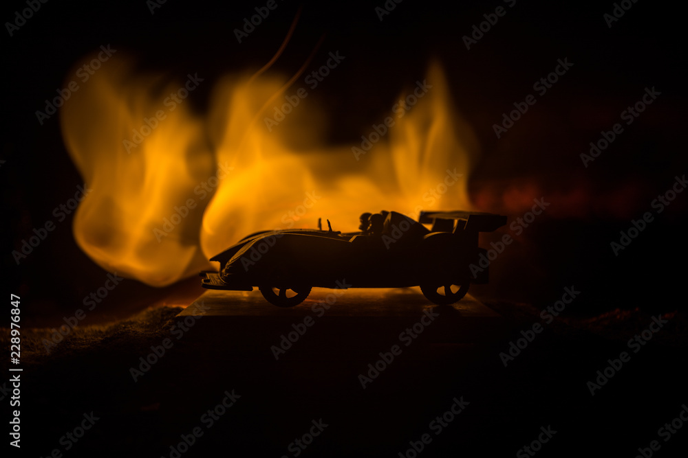 The car in the shadows with glowing lights in low light, or silhouette of sport car dark background.
