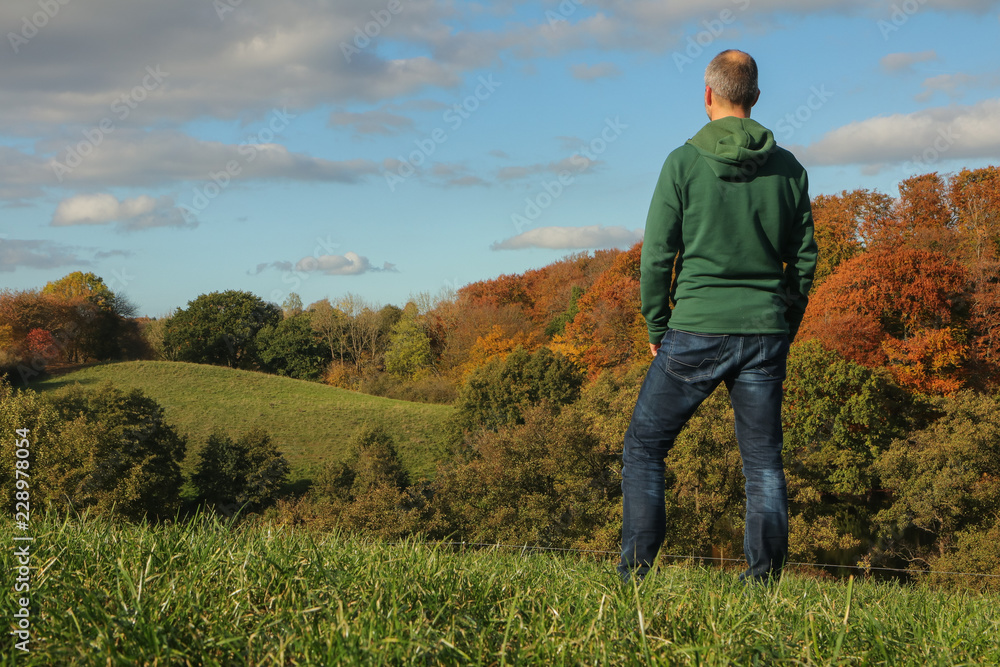 Mann genießt den Blick auf die schöne Herbst Landschaft bei Plön