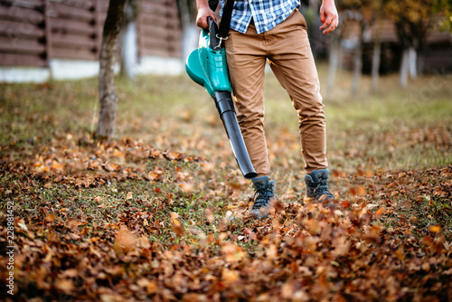 professional worker  man using leaf blower for autumn cleaning
