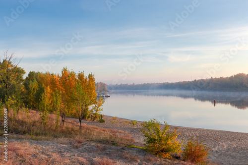 Section of plain river with sandy bank autumn at sunrise