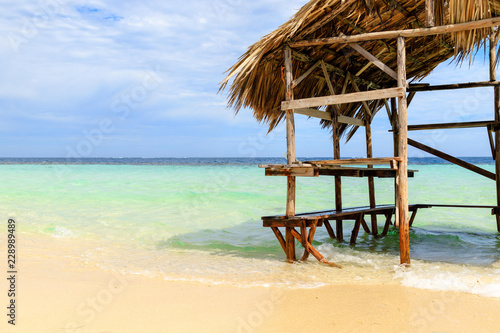 Fototapeta Naklejka Na Ścianę i Meble -  Beach hut with palm roof on the beach. Paradise Island, Dominican Republic.