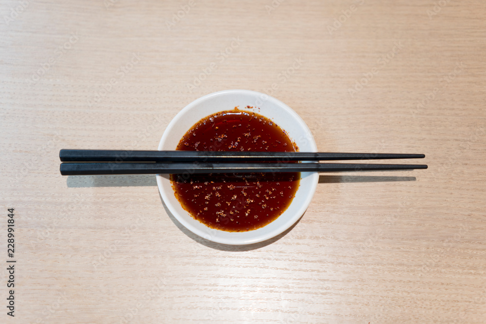 Sauce and chopsticks on wooden table Sauce and chopsticks on wooden table