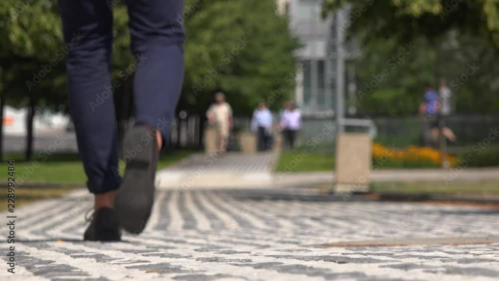 A businessman walks down a street - view from the ground