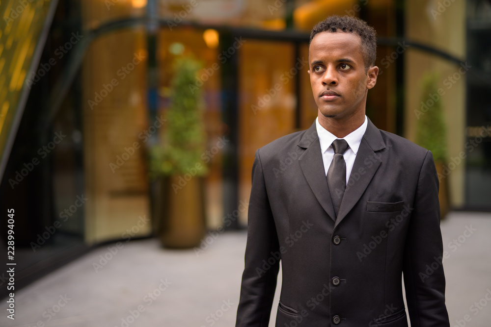 Portrait of young African businessman thinking outdoors Portrait of young African businessman thinking outdoors