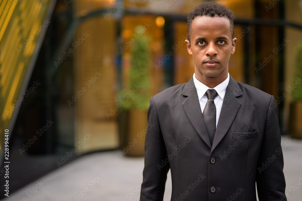 Portrait of young African businessman wearing suit outdoors Portrait of young African businessman wearing suit outdoors