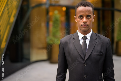 Portrait of young African businessman wearing suit outdoors © Ranta Images