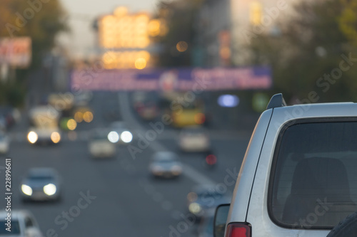 Cityscape with parts of the car on the blurred background of the road. © vvicca