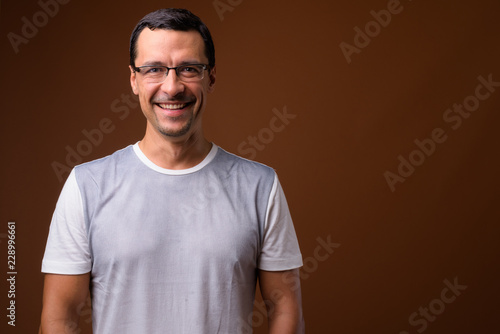 Portrait of happy man smiling against brown background