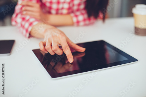 Young woman working with digital tablet.  Finger touching the screen.
