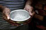 The poor old man's hands hold an empty bowl. The concept of hunger or poverty. Selective focus. Poverty in retirement.Homeless. Alms