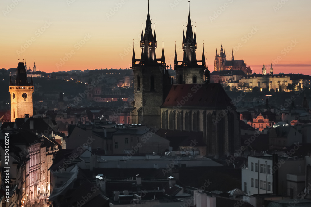 Veduta al tramonto della città di Praga con due dei monumenti principali : chiesa di Santa Maria di Tyn in primo piano e cattedrale di San Vito sullo sfondo