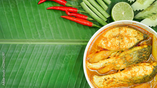 Thai hot and sour spicy yellow soup with sea fish in the white bowl ,decorate with vegetable on banana leaf,treditional southern Thai food,healty food , good food for diet and lose your weight photo