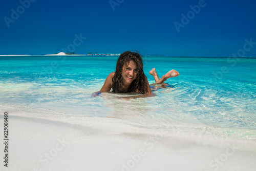 Beautiful tanned woman relaxing at tropical island on Maldives.