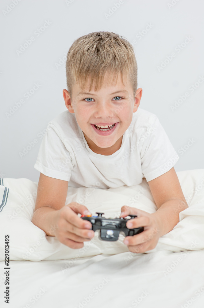 Happy little boy playing video games at home Happy little boy playing video games at home