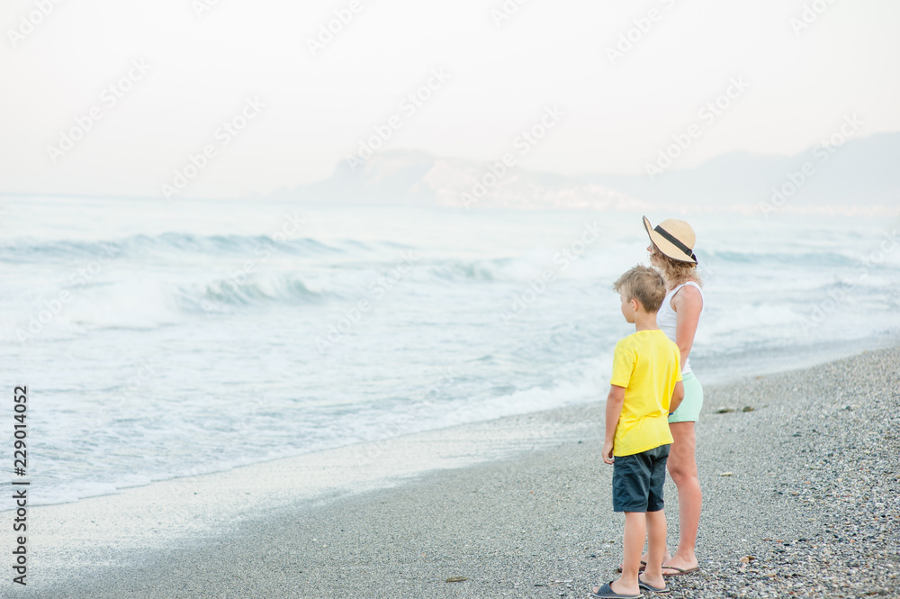 Mother and son standing  on the beach. Concept of friendly family at summer holiday