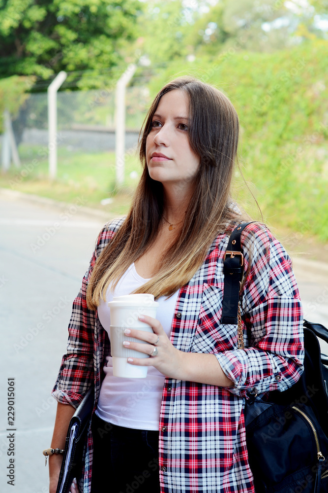 Woman holding paper coffee cup in the street. Woman holding paper coffee cup in the street.