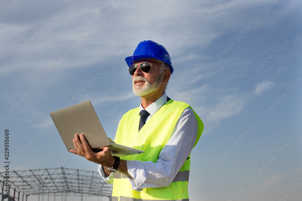 Engineer with laptop at building site Engineer with laptop at building site