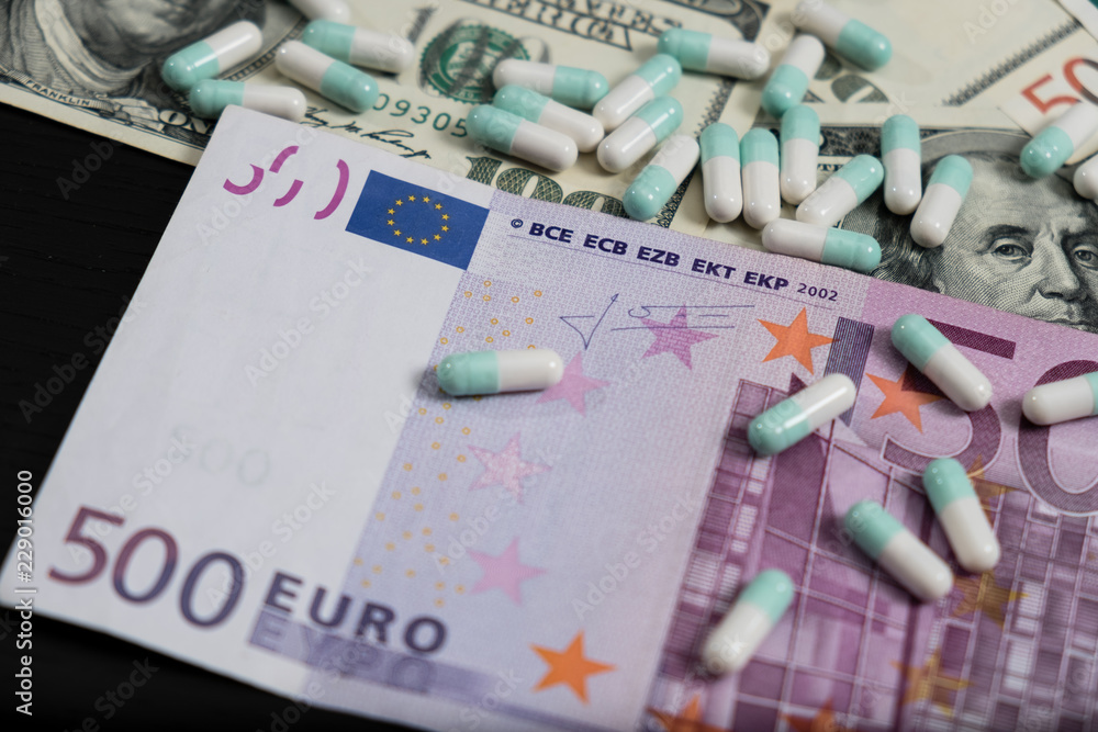 A bunch of pills and tablets on euro and dollar banknotes A bunch of pills and tablets on euro and dollar banknotes