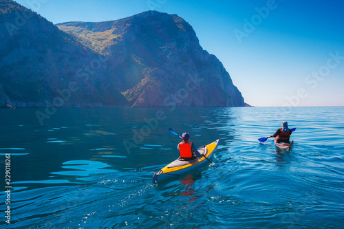 Kayaking. People swim in the sea kayak near the mountains. Adventures on the water photo