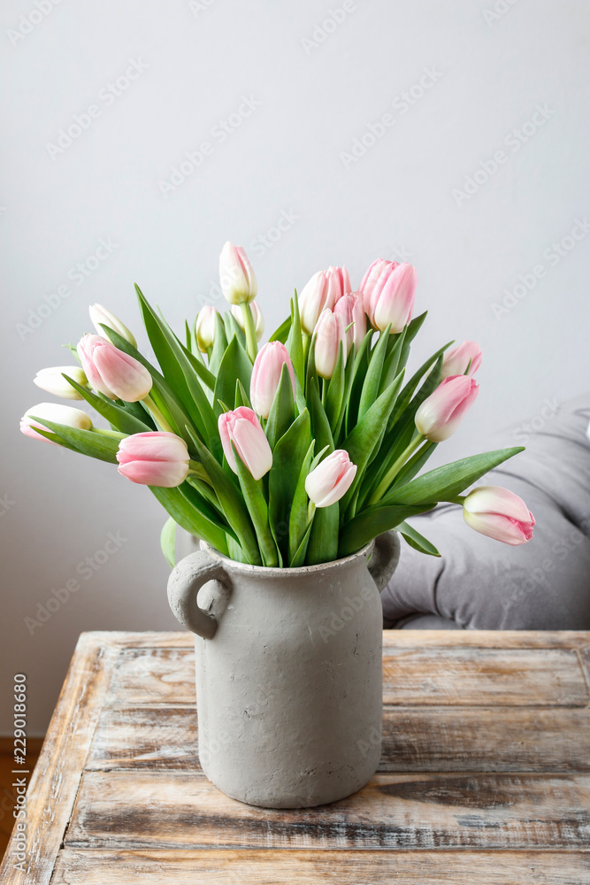 Bouquet of pink tulips in grey ceramic vase. - obrazy, fototapety, plakaty 