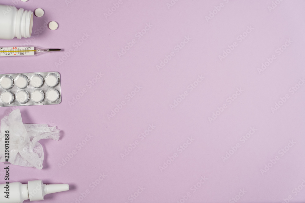 Various medicines, a thermometer, sprays from a stuffy nose and a pain in a throat on a pink background. Various medicines, a thermometer, sprays from a stuffy nose and a pain in a throat on a pink background.