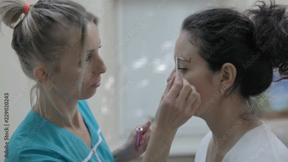 Close-Up Cosmetician Applies Special Eye Care Product to Beautiful Woman for Tattoo Close-Up Cosmetician Applies Special Eye Care Product to Beautiful Woman for Tattoo