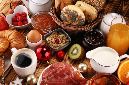 breakfast on table with bread buns, croissants, coffe and juice on christmas day. xmas holiday morning.