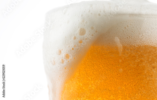 Closeup of a glass of beer with foaming bubbles.