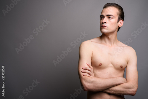 Young handsome man shirtless with arms crossed thinking