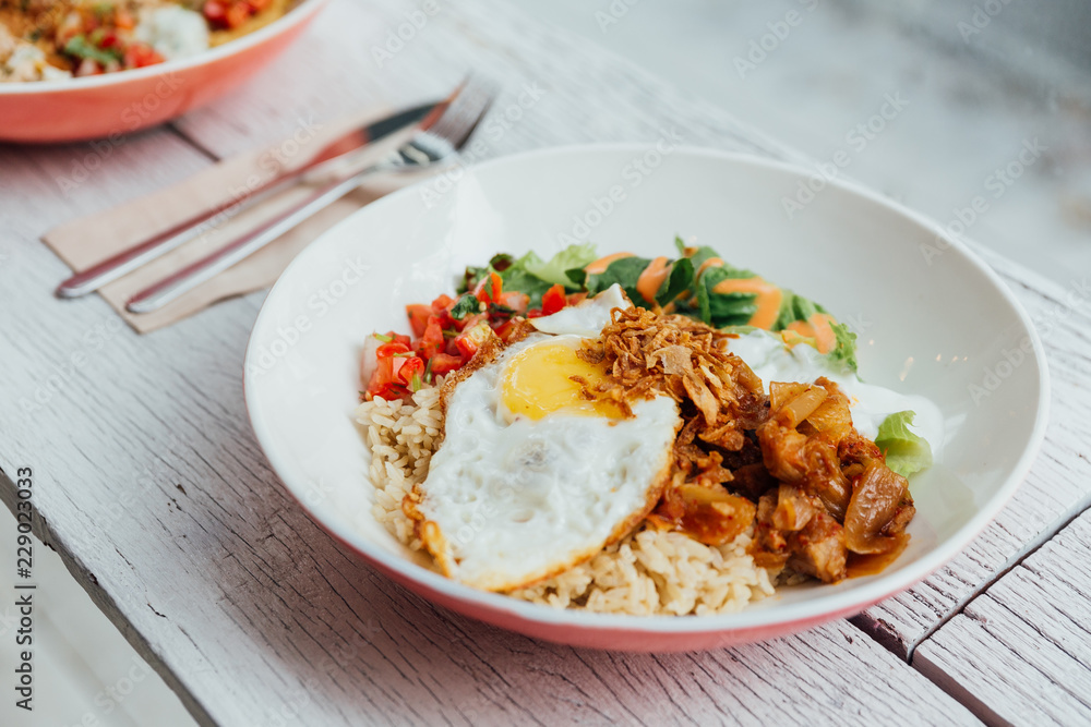 Fusion food Rice bowl toppings kimchi pork, organic fried egg, Korean eggplant and salad. Fusion food Rice bowl toppings kimchi pork, organic fried egg, Korean eggplant and salad.