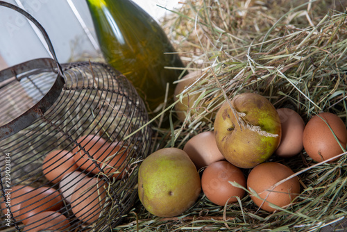 eggs, apples and bottlle of cider on the straw