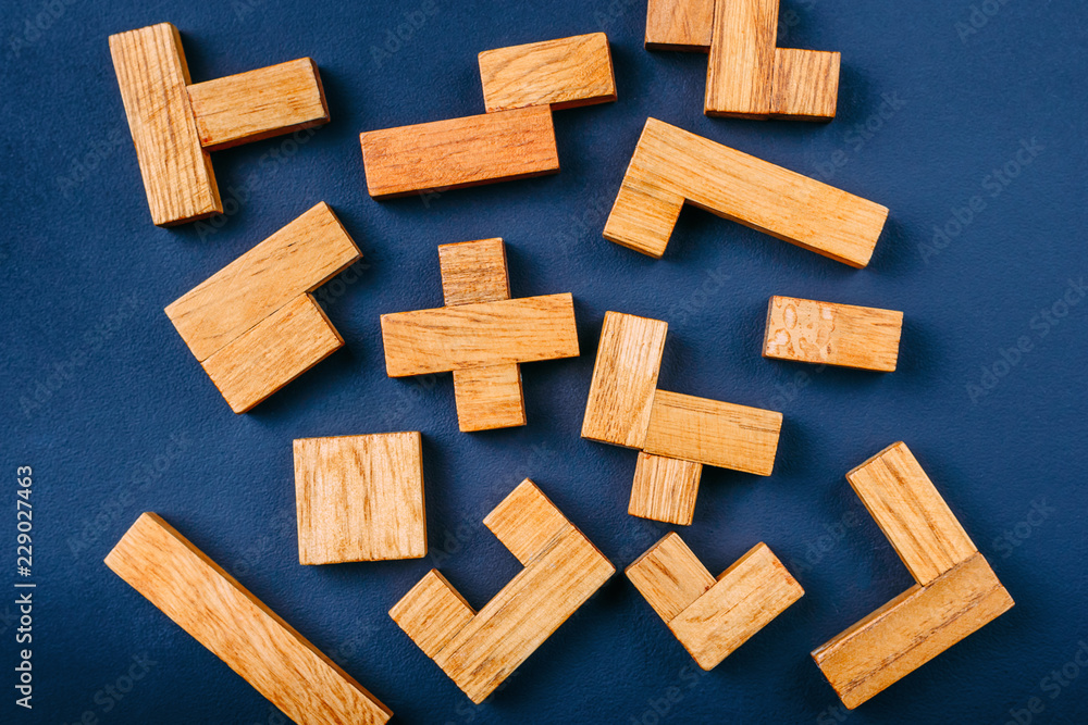 Different geometric shapes wooden blocks on a dark background. Creative, logical thinking and problem solving concept Different geometric shapes wooden blocks on a dark background. Creative, logical thinking and problem solving concept