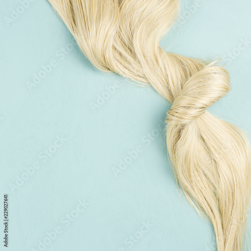 Hair extensions on blue wooden background. Top view