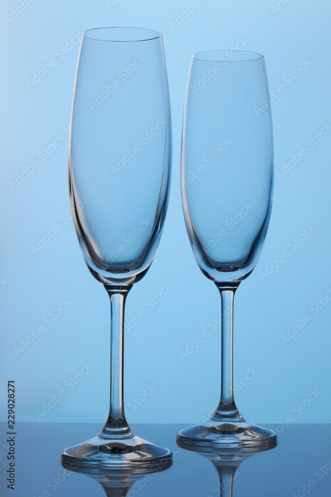 Two long champagne glasses. Blue lighting. Two long champagne glasses. Blue lighting.
