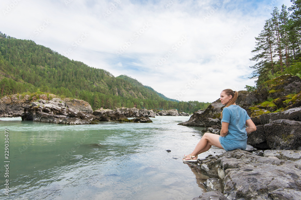 Woman resting at river in Altai Mountains territory