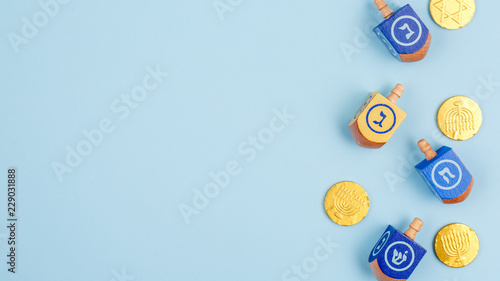фотографія Blue background with multicolor dreidels and chocolate coins