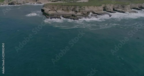 An aerial shot coming from the ocean into the cliffs at Bonny Doon Beach