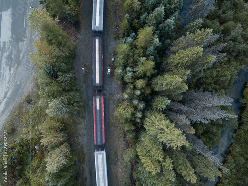Aerial drone shot of Canadian country side with road, rail, train and creek