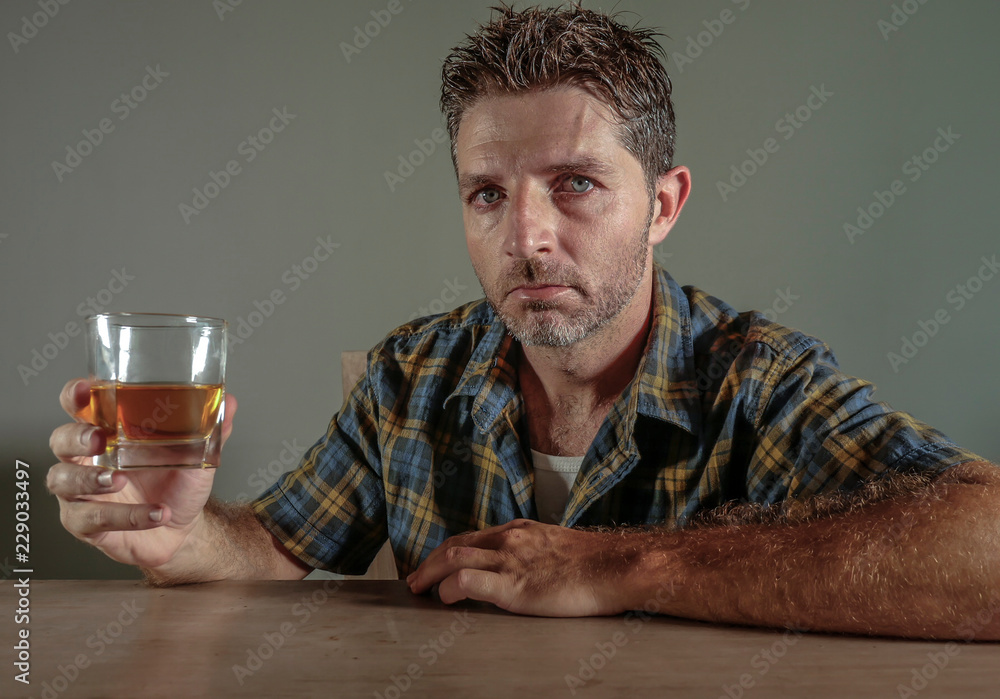 young attractive wasted and depressed addict and alcoholic man with whiskey glass thoughtful and sad failing resisting temptation to drink falling into alcohol abuse addiction young attractive wasted and depressed addict and alcoholic man with whiskey glass thoughtful and sad failing resisting temptation to drink falling into alcohol abuse addiction