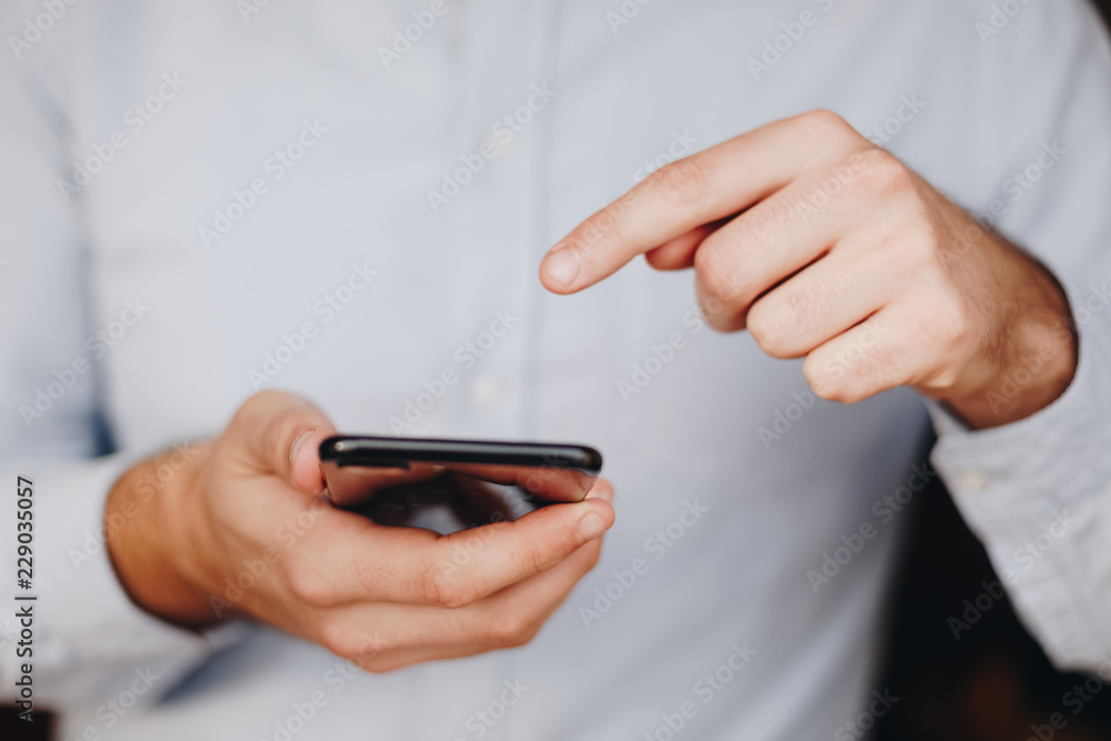 close up of man using smartphone. concept of phone addiction. young business man typing and browsing social media on his phone. close up of man using smartphone. concept of phone addiction. young business man typing and browsing social media on his phone.