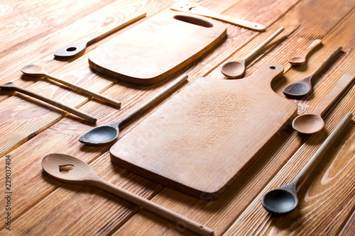 Wooden kitchen accessories on wood. Cutting boards and wooden spoons.