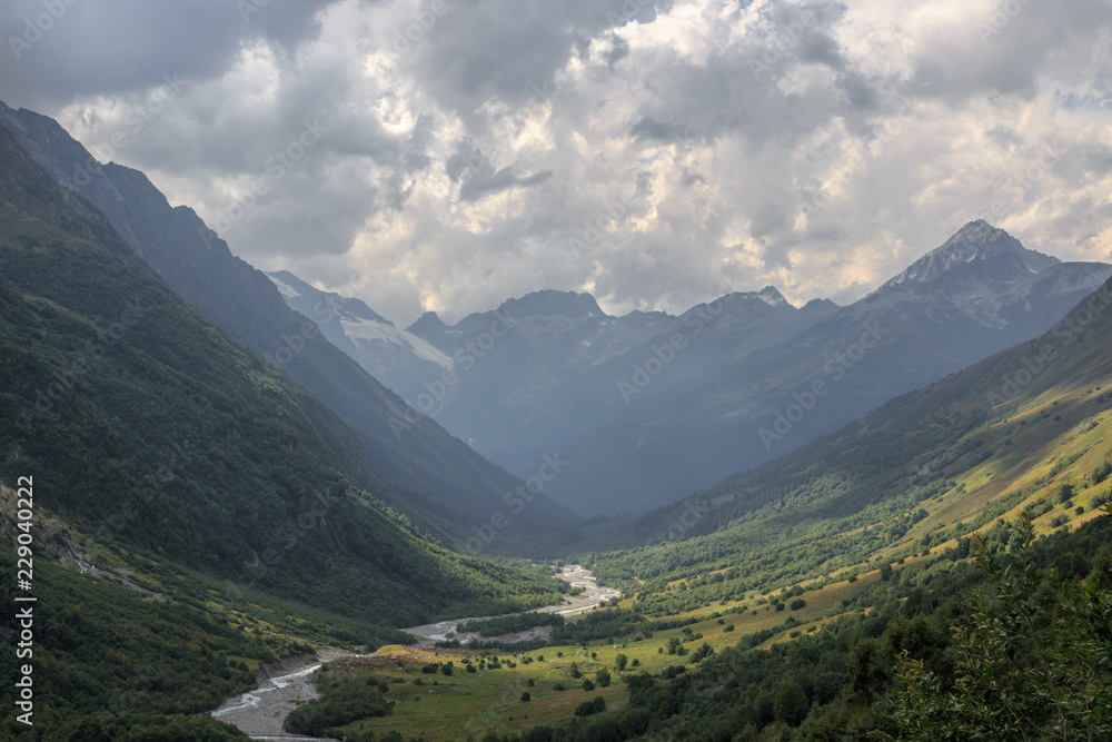 Closeup view mountains and river scenes in national park Dombai, Caucasus, Russia, Europe. Summer landscape, sunshine weather, dramatic blue sky and sunny day