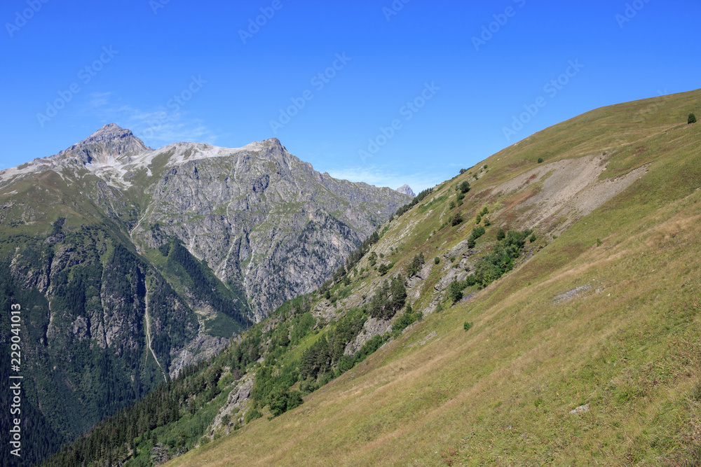 Closeup view mountains scenes in national park Dombai, Caucasus, Russia, Europe. Summer landscape, sunshine weather, dramatic blue sky and sunny day Closeup view mountains scenes in national park Dombai, Caucasus, Russia, Europe. Summer landscape, sunshine weather, dramatic blue sky and sunny day
