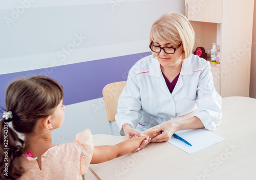 Pediatrician measuring girl’s heart rate