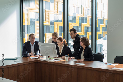 Business team look at one computer monitor