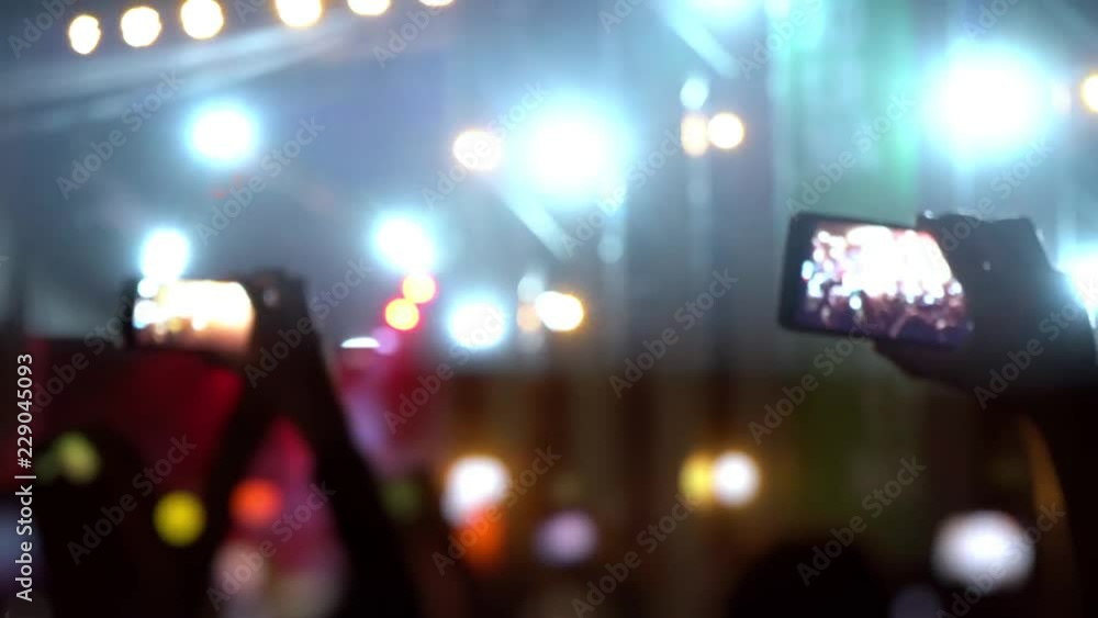 Fans are filming a concert on a smartphone. Live broadcast of the concert in social networks. People make photos and videos at the festival. World tour of popular musicians Fans are filming a concert on a smartphone. Live broadcast of the concert in social networks. People make photos and videos at the festival. World tour of popular musicians