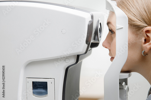 Young woman reception doctor ophthalmologist to check quality of eye vision.