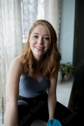 Portrait of smiling blond woman sitting indoors