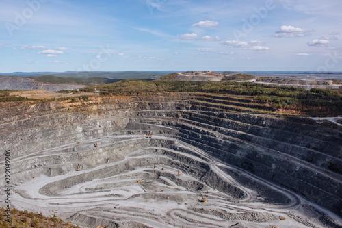 Aerial view industrial of opencast mining quarry with lots of machinery at work - view from above. Extraction of lime, chalk, calx, caol photo