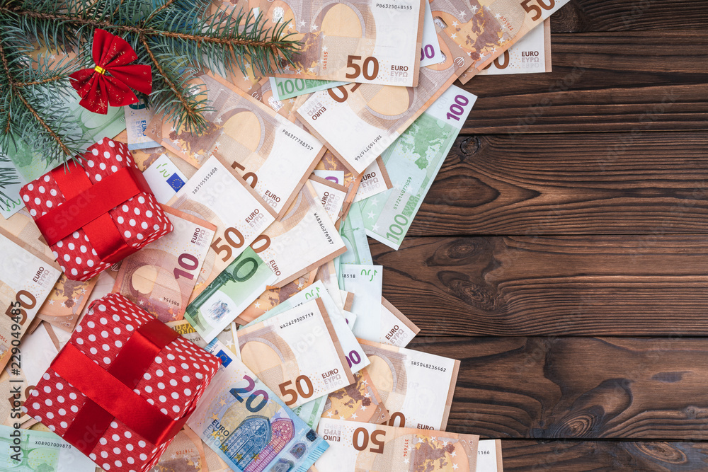 Christmas background with gifts on banknotes of different values. Planning book. Top view. Space for text. Christmas background with gifts on banknotes of different values. Planning book. Top view. Space for text.